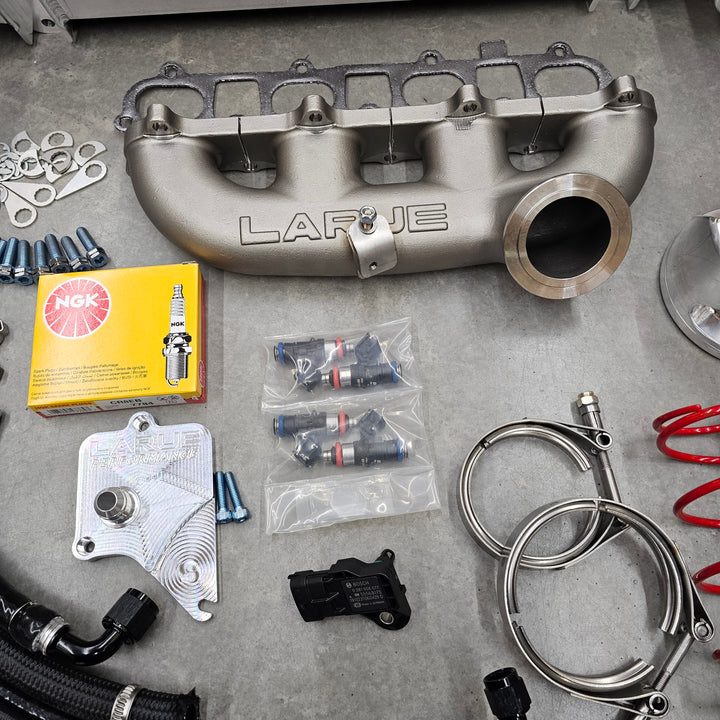 Collection of automotive parts, including a cast LaRue manifold, hoses, and connectors.